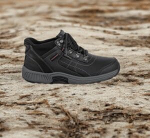 Bazaart_20260720_053217_955 - Rejuva Sole™ Black hiking shoe on a rugged, sandy ground; sturdy sole and laces visible, outdoors scenario