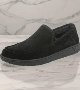 Bazaart_20260724_010717_525 - Rejuva Sole™ Black suede slip-on loafer with plush lining and chunky rubber sole, shown on a marble surface from the side.