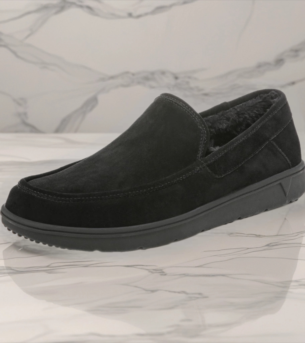 Bazaart_20260724_010717_525 - Rejuva Sole™ Black suede slip-on loafer with plush lining and chunky rubber sole, shown on a marble surface from the side.