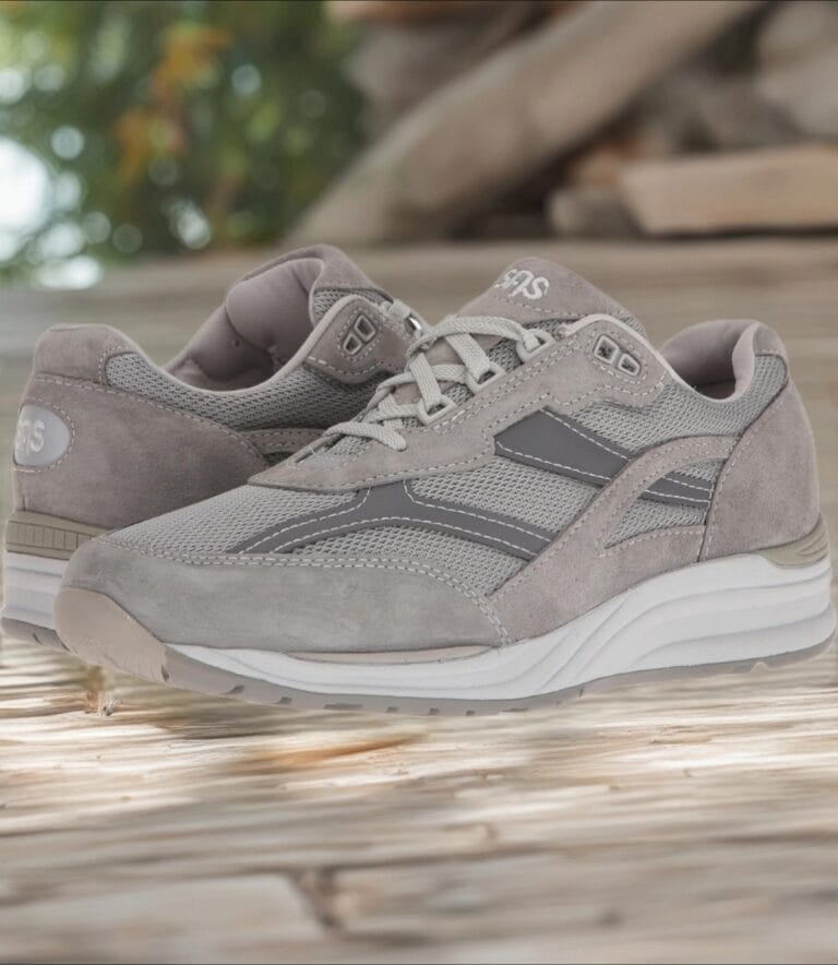 Grey athletic sneakers on a wooden surface, close-up of the side and laces, casual outdoor footwear